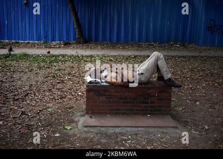 Un uomo senza tetto dorme sul banco del parco durante un governo ha imposto il blocco in mezzo all'epidemia del virus della corona a Dhaka, Bangladesh il 8 aprile 2020. (Foto di Syed Mahamudur Rahman/NurPhoto) Foto Stock