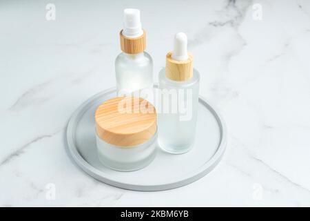 anti-aging collagen facial serum in frosted glass bottle and face cream on marble background with copy space. Natural Organic Cosmetic Beauty Concept. Stock Photo