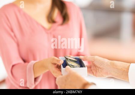 Mano, occhiali e visione con donna che acquista occhiali per la salute ottica e il benessere. Optometria, vendita al dettaglio e shopping con un acquisto di un cliente femminile Foto Stock