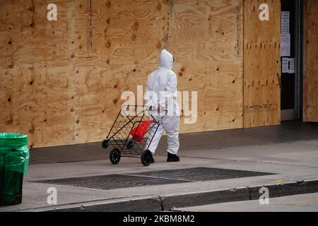 Una signora in tuta di nocciola passa da una struttura a Flushing Queens, USA., durante la pandemia di coronavirus il 10 aprile 2020. (Foto di John Nacion/NurPhoto) Foto Stock