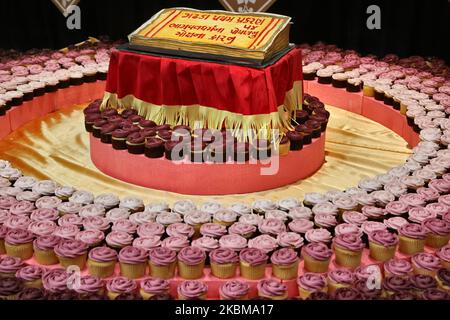 Cupcake accanto a montagne di dolci e spuntini vegetariani esposti di fronte alle divinità al tempio Swaminarayan BAPS Shri durante l'Annakut Darshan (noto anche come Annakut Utsav e Govardhan Puja) che si svolge il quinto e ultimo giorno del festival di Diwali, Che segna l'inizio del nuovo anno indù, a Toronto, Ontario, Canada, il 28 ottobre 2019. Annakut, che significa "una grande montagna di cibo" che viene offerto a Dio come segno di devozione. BAPS (Bochasanwasi Shri Akshar Purushottam Swaminarayan Sanstha) è una setta dei vidhi diksha dell'Induismo e dei loro templi, sebbene dedicati Foto Stock