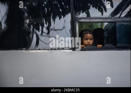 Un bambino guarda fuori dalla finestra dell'autobus durante un controllo della temperatura corporea di un passeggero che entrera' nella Citta' di Palu al confine con la Citta' di Palu, nella Provincia Centrale di Sulawesi, in Indonesia il 13 Aprile 2020. Il governo della città di Palu applica un sistema aperto-chiuso delle strade e conduce i controlli di salute per tutto e i passeggeri che entreranno nella città di Palu per impedire la diffusione di COVID -19. (Foto di Basri Marzuki/NurPhoto) Foto Stock