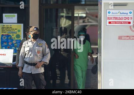 Un poliziotto si trova accanto all'ingresso della sala di trattamento presso l'Anutapura Regional General Hospital, Palu, Central Sulawesi Province, Indonesia, il 13 aprile 2020. Il Ministero della Salute della Repubblica di Indonesia ha annunciato il numero di persone infettate con COVID-19 dal 2 marzo 2020 ad aprile 13 2020 ha raggiunto 4.557 persone con la morte di 399 persone. Tutte le 34 province indonesiane sono state infettate da coronavirus. Il governo sta attualmente cercando di fornire attrezzature ospedaliere per gestire il crescente numero di pazienti. Il governo ha anche imposto Restri sociali su larga scala Foto Stock