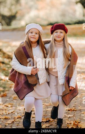 I bambini felici coccolano in un bellissimo parco autunnale Foto Stock