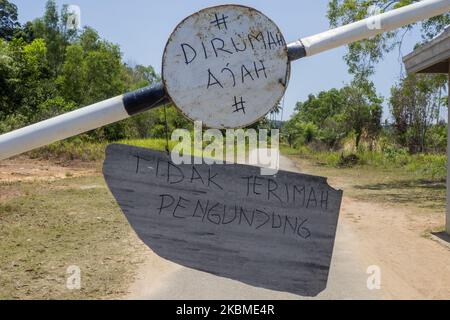 I residenti spruzzano liquido disinfettante e controllano la temperatura corporea sui veicoli utilizzati dai migranti che entreranno nell'area di Kampung Tui, Batam, Isole Riau, 15 aprile 2020. Un certo numero di Kampung tua a Batam ha implementato la quarantena di aree indipendenti come uno sforzo per prevenire e tagliare la diffusione di COVID-19 (Foto di Teguh Prihatna/NurPhoto) Foto Stock