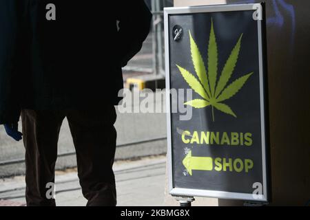 Una persona passa accanto a un cartello Cannabis Shop a Cracovia. Questa sera, il primo ministro Mateusz Morawiecki ha presentato il piano "Nuova normalità", che consiste in quattro fasi relative all'eliminazione delle restrizioni relative alle crisi del coronavirus, a partire dall'aprile 20. L'introduzione di fasi successive e la graduale eliminazione delle restrizioni dipenderanno principalmente dal numero di casi attivi di coronavirus. Giovedì 16 marzo 2020 a Cracovia, Polonia. (Foto di Artur Widak/NurPhoto) Foto Stock
