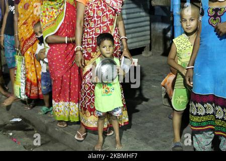 I baraccopoli aspettano in coda per ricevere cibo gratuito fuori dalla zona della stazione ferroviaria durante un blocco a Kolkata, India, il 17 aprile 2020. Il primo ministro indiano Narendra modi martedì ha esteso il blocco del coronavirus più grande del mondo per far decapare il picco dell'epidemia, con funzionari che corrono per recuperare il tempo perduto. (Foto di Debajyoti Chakraborty/NurPhoto) Foto Stock