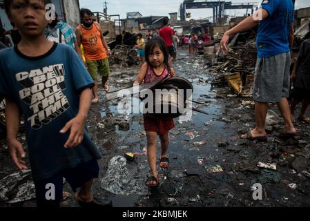 Una ragazza trasporta i detriti del fuoco per essere venduto nei negozi della roba di rifiuto dopo che un incendio è scoppiato in una zona della baraccopoli a tondo, Manila nelle Filippine il 18 aprile 2020. Circa 500 famiglie hanno perso le loro case, mentre Manila e l'intera isola di Luzon rimangono in quarantena. Il numero di casi COVID-19 confermati nel paese supera i 6.000.(Foto di Lisa Marie David/NurPhoto) Foto Stock