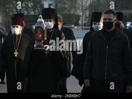 I sacerdoti ortodossi della Chiesa ortodossa Ucraina di Mosca, sostenuta dalla Russia, portano il Santo fuoco dopo che è stato consegnato da Gerusalemme durante la celebrazione ortodossa di Pasqua vicino a Kyiv-Pechersk Lavra a Kyiv, Ucraina, 18 aprile 2020. La Pasqua è celebrata in tutto il mondo dai cristiani per segnare la risurrezione di Gesù Cristo dai morti e il fondamento della fede cristiana. . (Foto di Sergii Kharchenko/NurPhoto) Foto Stock