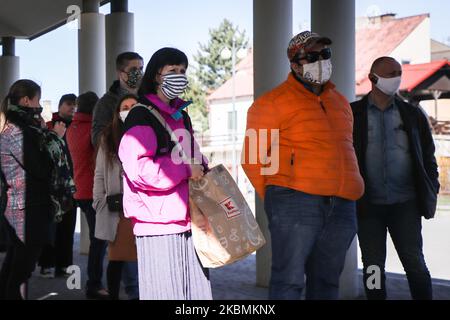 La gente partecipa alla Festa della Misericordia presso il Santuario della Divina Misericordia a Lagiewniki durante la diffusione del coronavirus. Cracovia, Polonia il 19 aprile 2020. La Festa della Divina Misericordia, istituita da papa Giovanni Paolo II, si celebra la prima domenica dopo Pasqua, e in quella data si celebra l'annuale apogeo dei pellegrinaggi al santuario. A causa della pandemia di coronavirus e secondo l'ordinanza dello Stato e delle autorità della chiesa, un massimo di cinque persone possono partecipare alla Messa e ai servizi in chiesa. I partecipanti alla Messa devono aspettare in fila, mantenendo una distanza sicura, se vogliono pregare Foto Stock