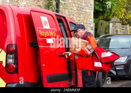 Il lavoratore postale di Royal Mail effettua consegne nel suo turno a Batheaston, Somerset, Inghilterra, Regno Unito Foto Stock