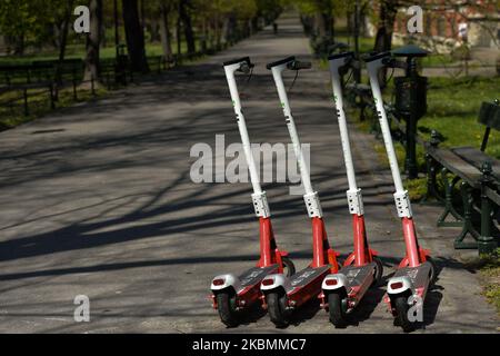 Gli scooter elettrici parcheggiati sul lato del Planty Park di Cracovia, dato che i polacchi possono ora godere di nuovo dello spazio verde. Da oggi (aprile 20) è stato revocato il divieto di spostarsi, viaggiare e soggiornare in luoghi pubblici. I parchi pubblici, le foreste e le spiagge sono stati riaperti, ad eccezione dei parchi giochi e delle strutture sportive. I bambini di età superiore ai 13 anni possono spostarsi senza genitori; la copertura della bocca e del naso in pubblico rimane ancora obbligatoria. I parchi giochi e le strutture sportive rimangono chiusi. Lunedì 20 aprile 2020 a Cracovia, Polonia. (Foto di Artur Widak/NurPhoto) Foto Stock