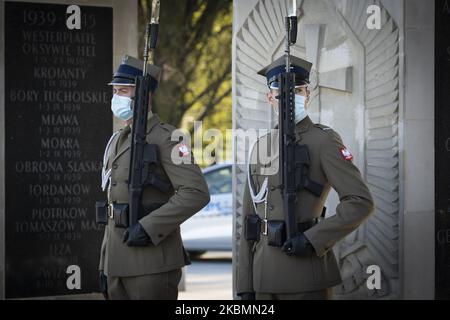 I soldati che indossano maschere facciali sono visti durante il cambio della guardia alla Tomba del Milite Ignoto a Varsavia, Polonia, il 20 aprile 2020. Poiché la Polonia ha raggiunto domenica il picco di nuove infezioni da COVID-19, da quando la prima vittima è stata registrata all'inizio di marzo, il governo sta lentamente alleggerendo le restrizioni sulla vita pubblica consentendo alle persone di utilizzare parchi e foreste. Nelle prossime settimane verrà annunciato un ulteriore allentamento, in quanto il governo è fiducioso che il picco dell'epidemia sarà raggiunto in aprile o all'inizio di maggio. Si prevede che le misure di quarantena provochino un calo del 4-5% del PIL e un doub Foto Stock