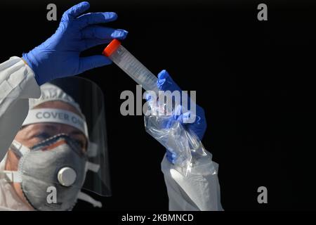 Diagnostics Medical Laboratories worker checking a test tube before performing a swab to collect a sample for coronavirus testing at Tauron Arena drive-thru testing center in Krakow. The private company charges 584 Polish zloty (around 130 euro) for the test. The number infected by the virus continues to grow in Poland and the Health Ministry reported today 263 new cases and 21 deaths, before 5pm, rising the total count to 9,865 people infected, 401 deaths and 1,297 recovered. On Tuesday, April 21, 2020, in Krakow, Poland. (Photo by Artur Widak/NurPhoto) Stock Photo