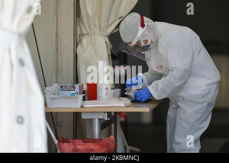 Il dipendente dei Laboratori medici di diagnostica si prepara ad eseguire un tampone per prelevare un campione per l'analisi del coronavirus presso il centro di test drive-thru Tauron Arena di Cracovia. La società privata addebita 584 zloty polacco (circa 130 euro) per il test. Il numero di contagiati dal virus continua a crescere in Polonia e il Ministero della Salute ha riferito oggi 263 nuovi casi e 21 morti, prima del 5pm, aumentando il numero totale a 9.865 persone infette, 401 morti e 1.297 guarite. Martedì 21 aprile 2020 a Cracovia, Polonia. (Foto di Artur Widak/NurPhoto) Foto Stock