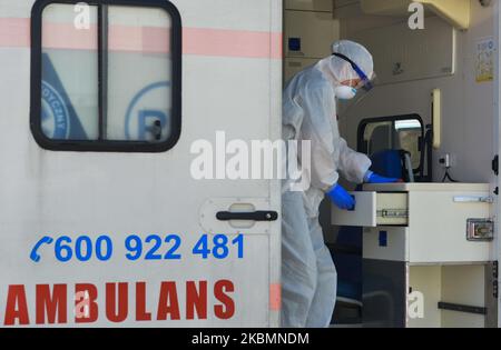 Un operatore medico che indossa tuta di nocciola e casco protettivo e maschera, visto all'interno di un'ambulanza presso il parcheggio del reparto di malattia infettiva dell'Ospedale Universitario di Cracovia, dopo l'arrivo con un paziente sospettato di essere stato infettato da coronavirus. Martedì 21 aprile 2020 a Cracovia, Polonia. (Foto di Artur Widak/NurPhoto) Foto Stock