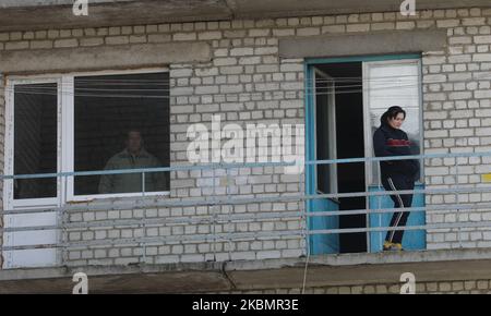 La gente guarda giù dai balconi del loro condominio di era sovietica come l'epidemia è stata rilevata in un edificio e 38 casi di infezione sono stati confermati nella città di Vyshneve vicino a Kyiv, Ucraina, 22 aprile 2020. Il Gabinetto dei ministri dell'Ucraina ha prorogato le misure di quarantena fino a metà maggio con tutte le misure preventive in quanto nel paese sono stati confermati 6592 casi di coronavirus COVID-19 (Foto di Sergii Kharchenko/NurPhoto) Foto Stock