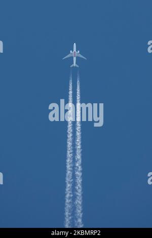 Un aereo Emirates Sky Cargo Boeing 777F visto sorvolare nel cielo blu greco sopra la città di Salonicco, Grecia, il 23 aprile 2020 formando contraglie o scie chimiche, vapore bianco dietro. L'aereo è un Boeing B777-F1H con registrazione A6-EFF che vola a 34,000feet km da Dubai, UAE DXB aeroporto internazionale a Madrid, Spagna MAD che trasporta forniture di carico durante l'era pandemica di Coronavirus COVID-19. Emirates SkyCargo è la divisione di trasporto aereo di Emirates Airlines. (Foto di Nicolas Economou/NurPhoto) Foto Stock