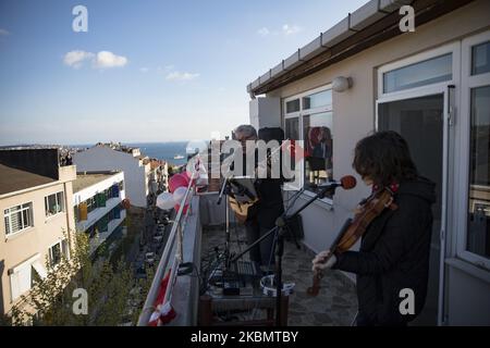 Due persone si esibiscono su un tetto mentre la band musicale 'Eren Joseph Dwyer & Paul Dwyer' offre un concerto dal loro balcone all'interno delle celebrazioni che segnano la sovranità nazionale e la Giornata dei bambini a Istanbul, in Turchia, il 23 aprile 2020. Il Ministero dell'interno turco ha annunciato che Istanbul e 30 grandi città saranno sotto blocco dal 23 al 26 aprile 2020 in mezzo alla pandemia di coronavirus COVID-19 in corso. La Turchia ha sospeso tutti i voli internazionali e tutti i viaggi interurbani sono soggetti all'autorizzazione delle autorità locali nell'ambito di misure volte a prevenire la diffusione della pandemia della malattia COVID-19 causata da b Foto Stock