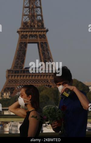 Una coppia a piedi sul ponte Mirabeau un fronte la Torre Eiffel a Parigi, il 23 aprile 2020 a Parigi, Francia. La pandemia di Coronavirus (COVID-19) si è diffusa in molti paesi del mondo. Foto Stock