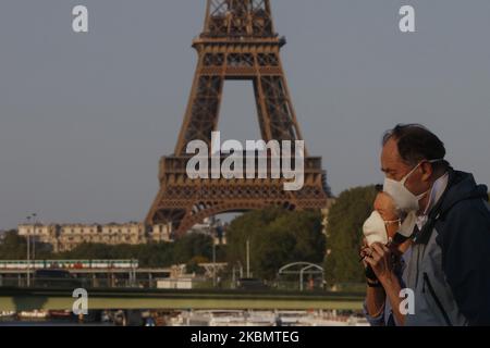 Una coppia a piedi sul ponte Mirabeau un fronte la Torre Eiffel a Parigi, il 23 aprile 2020 a Parigi, Francia. La pandemia di Coronavirus (COVID-19) si è diffusa in molti paesi del mondo. Foto Stock