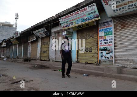 In India blocco a causa della pandemia COVID-19 (coronavirus), un uomo che indossa una maschera cammina oltre le persiane chiuse nel Gurugram alla periferia di Nuova Delhi, India il 24 aprile 2020. (Foto di Nasir Kachroo/NurPhoto) Foto Stock