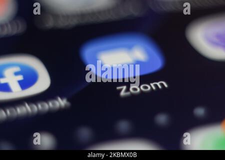 ZOOM Video Communications viene visualizzato sullo schermo del telefono, le miniature dell'applicazione, dello smartphone e della tastiera vengono visualizzate in questa illustrazione con esposizione multipla. Zoom è un'azienda americana di tecnologia delle comunicazioni con sede a San Jose, California. Fornisce servizi di videotelefonia e chat online tramite una piattaforma software peer-to-peer basata su cloud ed è utilizzata per teleconferenze, telelavoro, formazione a distanza e relazioni sociali. Zoom App e la comunicazione divenne molto popolare durante il Covid-19, Coronavirus pandemic quarantena blocco e distensione sociale come la gente starte Foto Stock