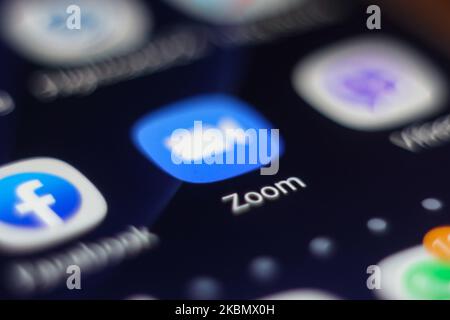 ZOOM Video Communications viene visualizzato sullo schermo del telefono, le miniature dell'applicazione, dello smartphone e della tastiera vengono visualizzate in questa illustrazione con esposizione multipla. Zoom è un'azienda americana di tecnologia delle comunicazioni con sede a San Jose, California. Fornisce servizi di videotelefonia e chat online tramite una piattaforma software peer-to-peer basata su cloud ed è utilizzata per teleconferenze, telelavoro, formazione a distanza e relazioni sociali. Zoom App e la comunicazione divenne molto popolare durante il Covid-19, Coronavirus pandemic quarantena blocco e distensione sociale come la gente starte Foto Stock