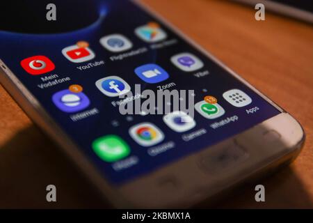 ZOOM Video Communications viene visualizzato sullo schermo del telefono, le miniature dell'applicazione, dello smartphone e della tastiera vengono visualizzate in questa illustrazione con esposizione multipla. Zoom è un'azienda americana di tecnologia delle comunicazioni con sede a San Jose, California. Fornisce servizi di videotelefonia e chat online tramite una piattaforma software peer-to-peer basata su cloud ed è utilizzata per teleconferenze, telelavoro, formazione a distanza e relazioni sociali. Zoom App e la comunicazione divenne molto popolare durante il Covid-19, Coronavirus pandemic quarantena blocco e distensione sociale come la gente starte Foto Stock