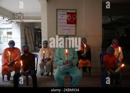 7th° anniversario della tragedia di Rana Plaza osservata il 24 aprile 2020 a Dhaka, Bangladesh, in mezzo alla pandemia di Coronavirus della Bangladesh Garments Federation, i bambini della vittima hanno acceso sette candele per protestare. (Foto di Sony Ramany/NurPhoto) Foto Stock