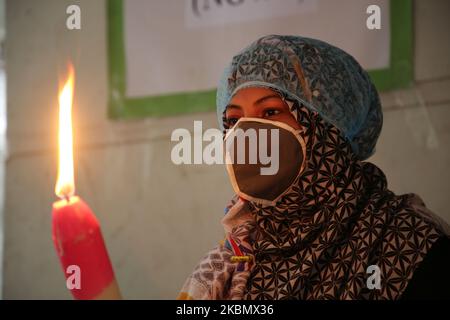 7th° anniversario della tragedia di Rana Plaza osservata il 24 aprile 2020 a Dhaka, Bangladesh, in mezzo alla pandemia di Coronavirus della Bangladesh Garments Federation, i bambini della vittima hanno acceso sette candele per protestare. (Foto di Sony Ramany/NurPhoto) Foto Stock