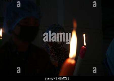 7th° anniversario della tragedia di Rana Plaza osservata il 24 aprile 2020 a Dhaka, Bangladesh, in mezzo alla pandemia di Coronavirus della Bangladesh Garments Federation, i bambini della vittima hanno acceso sette candele per protestare. (Foto di Sony Ramany/NurPhoto) Foto Stock