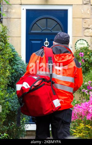 Il lavoratore postale di Royal Mail effettua consegne nel suo turno a Batheaston, Somerset, Inghilterra, Regno Unito Foto Stock