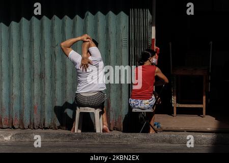 Una coppia che espone le spalle alla luce del sole a San Jose, Antipolo City, Filippine, il 28 aprile 2020. Secondo gli studi, la luce solare può aumentare la vitamina D del corpo, che è buono per i polmoni. E anche alcuni ricercatori dicono, il virus Covid-19 non può sopravvivere più a lungo quando è esposto a una luce solare diretta. (Foto di Ryan Eduard Benaid/NurPhoto) Foto Stock