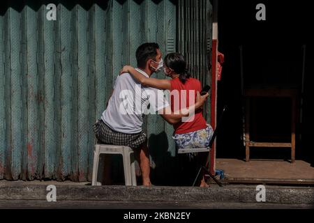 Una coppia che espone le spalle alla luce del sole a San Jose, Antipolo City, Filippine, il 28 aprile 2020. Secondo gli studi, la luce solare può aumentare la vitamina D del corpo, che è buono per i polmoni. E anche alcuni ricercatori dicono, il virus Covid-19 non può sopravvivere più a lungo quando è esposto a una luce solare diretta. (Foto di Ryan Eduard Benaid/NurPhoto) Foto Stock