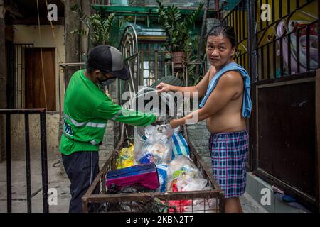 Alquin Flores, un raccoglitore di rifiuti, raccoglie i rifiuti domestici in un quartiere a Quezon City, Filippine il 29 aprile 2020. Anche acclamati come frontliner, i raccoglitori di rifiuti continuano a lavorare a stretto contatto con diversi rifiuti nonostante i rischi per la salute e la mancanza di dispositivi di protezione individuale (DPI). Ad oggi, le Filippine hanno registrato un totale di 8.212 casi di COVID-19, 558 morti e 1.023 riprese.(Foto di Lisa Marie David/NurPhoto) Foto Stock