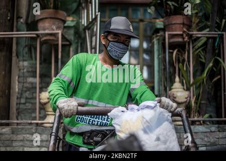 Alquin Flores, un raccoglitore di rifiuti, raccoglie i rifiuti domestici in un quartiere a Quezon City, Filippine il 29 aprile 2020. Anche acclamati come frontliner, i raccoglitori di rifiuti continuano a lavorare a stretto contatto con diversi rifiuti nonostante i rischi per la salute e la mancanza di dispositivi di protezione individuale (DPI). Ad oggi, le Filippine hanno registrato un totale di 8.212 casi di COVID-19, 558 morti e 1.023 riprese.(Foto di Lisa Marie David/NurPhoto) Foto Stock