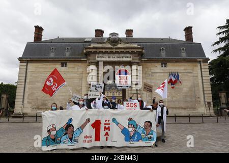 Gli attivisti dell'Unione dell'ospedale brandish un grande banner firmato dall'artista DUGUDUS di fronte all'ospedale Pitie Salpetriere di Parigi, come un blocco è imposto per rallentare il tasso della malattia di coronavirus (COVID-19) in Francia, 30 aprile 2020. (Foto di Mehdi Taamallah/NurPhoto) Foto Stock