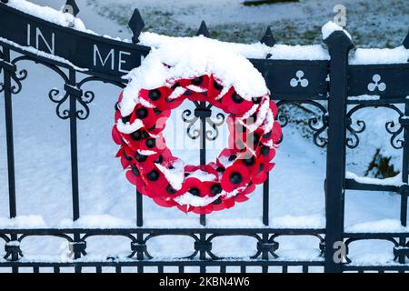 Corona di papavero su un cancello della chiesa nella neve Foto Stock