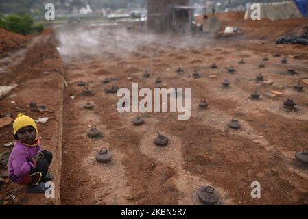 Una bambina che gioca come suo padre che lavora intorno alla zona di fuoco il giorno del lavoro durante il blocco completo della nazione come preoccupazioni circa la diffusione del virus di Corona (COVID-19) a Kathmandu, Nepal il 01 maggio 2020. (Foto di Narayan Maharjan/NurPhoto) Foto Stock