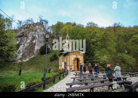 Le persone che indossano coperture per il viso e maschere mediche che frequentano la messa sacra nella cappella di legno sull'acqua sono viste in Ojcow, Parco Nazionale di Ojcow (Parco di Ojcowski Narodowy) area Polonia , il 1 maggio 2020 come nuovo regolamento pandemico di Coronavirus, Il governo polacco ha permesso a 1 persona per 15 m2 della chiesa di partecipare alla messa sacra. Cappella di San Giuseppe Artigianato (Workman) 'sull'acqua' si trova presso il sito delle antiche terme, che è stato convertito in un oggetto sacrale nel 1901. (Foto di Michal Fludra/NurPhoto) Foto Stock