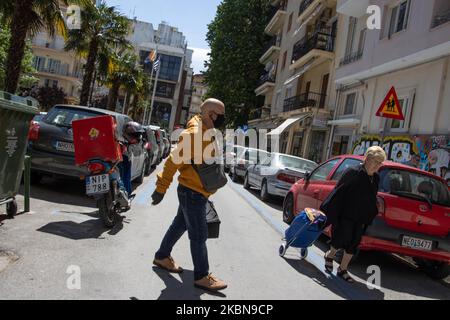 Persona che porta cibo visto indossare una maschera facciale. Strade quasi vuote di Salonicco un giorno prima di allentare la prevenzione contro il Covid-19 Coronavirus Pandemic misure focolaio e restrizioni del traffico in cui i cittadini sono autorizzati a uscire dalle loro case solo con speciale permesso scritto o SMS. Un coprifuoco è stato applicato anche in alcuni luoghi popolari come la New Promenade, che è stato rimosso alcuni giorni fa. La Grecia solleverà il blocco e faciliterà il suo soggiorno obbligatorio a casa quarantena per tutti i cittadini Lunedi 4 maggio, 2020. La Grecia ha registrato 2.534 infezioni da COVID-19 e 145 decessi. Maggio Foto Stock
