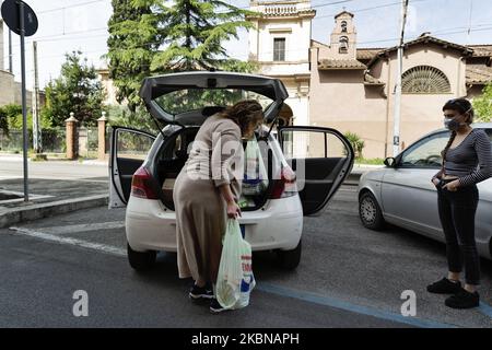 Alcuni volontari dell'esperienza Baobab, un'organizzazione che ha organizzato una rete di donazione e distribuzione di cibo per oltre 1000 migranti in tutta la città, 20 aprile, Roma, Italia. L'organizzazione ha assistito i migranti dal 2015 e ci sono oltre 100 volontari. Essi stanno adottando tutte le misure precauzionali per distribuire le parcelle alimentari. (Foto di Matteo Trevisan/NurPhoto) Foto Stock