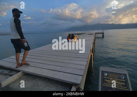 Un certo numero di residenti si rilassano mentre si gode l'atmosfera del tramonto a Wani Village, Donggala Regency, Central Sulawesi Province, Indonesia, il 5 maggio, 2020. Alcune persone del villaggio trascorrono il loro tempo rilassandosi in spiaggia per superare la noia e la noia a causa della riduzione delle attività lavorative durante la pandemia del virus corona (COVID-19). (Foto di Mohamad Hamzah/NurPhoto) Foto Stock