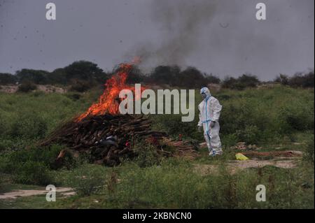 Una dom che indossa un abbigliamento protettivo, esegue il rituale del corpo morto di un paziente, è morto di COVID-19 nella periferia di Allahabad, durante il blocco nazionale imposto dal governo come misura preventiva contro COVID-19 coronavirus, in Allahabad il 6,2020 maggio. (Foto di Ritesh Shukla/NurPhoto) Foto Stock