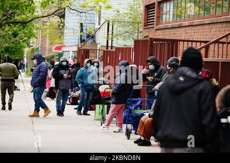 Una vista di una lunga fila di persone che si estende 4 blocchi per i beni di soccorso in Elmcor Building a Corona, Queens, New York, USA durante la pandemia di Coronavirus il 6 maggio 2020. (Foto di John Nacion/NurPhoto) Foto Stock