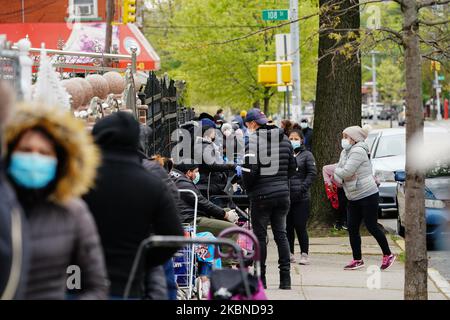 Una vista di una lunga fila di persone che si estende 4 blocchi per i beni di soccorso in Elmcor Building a Corona, Queens, New York, USA durante la pandemia di Coronavirus il 6 maggio 2020. (Foto di John Nacion/NurPhoto) Foto Stock