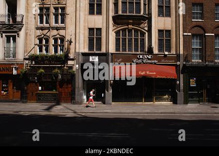 Un uomo passa accanto a pub e ristoranti chiusi in un vicino deserto Whitehall a Londra, Inghilterra, il 6 maggio 2020. La Gran Bretagna è ormai ben entrata nella sua settima settimana di blocco del coronavirus, anche se si prevede che questa domenica sarà annunciato un leggero allentamento delle restrizioni, insieme a un calendario per ulteriori 'agevolazioni' nei prossimi mesi. Secondo le cifre attuali del Dipartimento della Salute e dell'assistenza sociale del Regno Unito, i decessi di Covid-19 in tutto il paese hanno raggiunto nel frattempo 30.076. Attualmente la cifra è considerata la più alta in Europa, anche se gli esperti hanno avvertito che potrebbe essere di alcuni mesi Foto Stock