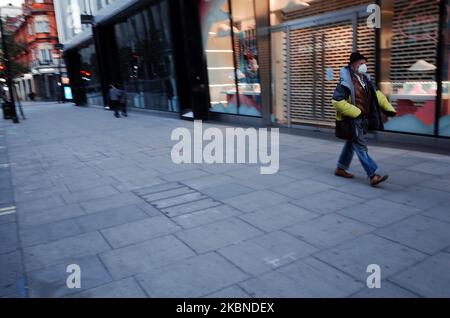 A man wearing a face mask walks along a near-deserted Oxford Street in London, England, on May 6, 2020. Britain is now well into its seventh week of coronavirus lockdown, although a slight easing of the restrictions is expected to be announced this Sunday, along with a schedule for further 'easements' over the coming months. Covid-19 deaths across the country have meanwhile reached 30,076 according to today's figures from the UK's Department of Health and Social Care. The figure is currently considered to be the highest in Europe, though experts have cautioned that it may be some months before Stock Photo