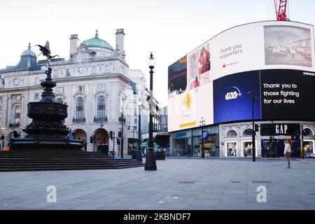 A woman takes a photo of a near-deserted Piccadilly Circus in London, England, on May 6, 2020. Britain is now well into its seventh week of coronavirus lockdown, although a slight easing of the restrictions is expected to be announced this Sunday, along with a schedule for further 'easements' over the coming months. Covid-19 deaths across the country have meanwhile reached 30,076 according to today's figures from the UK's Department of Health and Social Care. The figure is currently considered to be the highest in Europe, though experts have cautioned that it may be some months before accurate Stock Photo